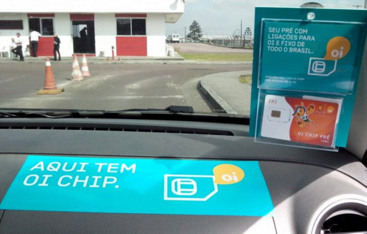 Adesivos nos táxis informam sobre a venda da Oi. Foto: Divulgação.