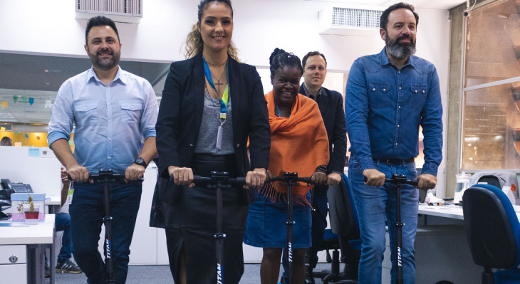 Braulio Lalau de Carvalho, CEO da Orbitall (na ponta direita), passeia de patinete com colegas.
