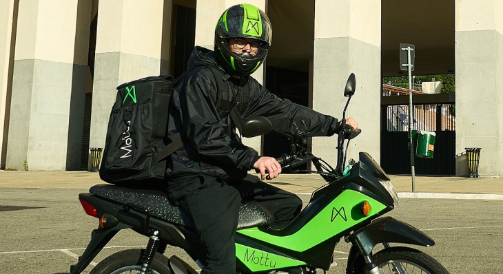 Entregador com moto alugada da Mottu.